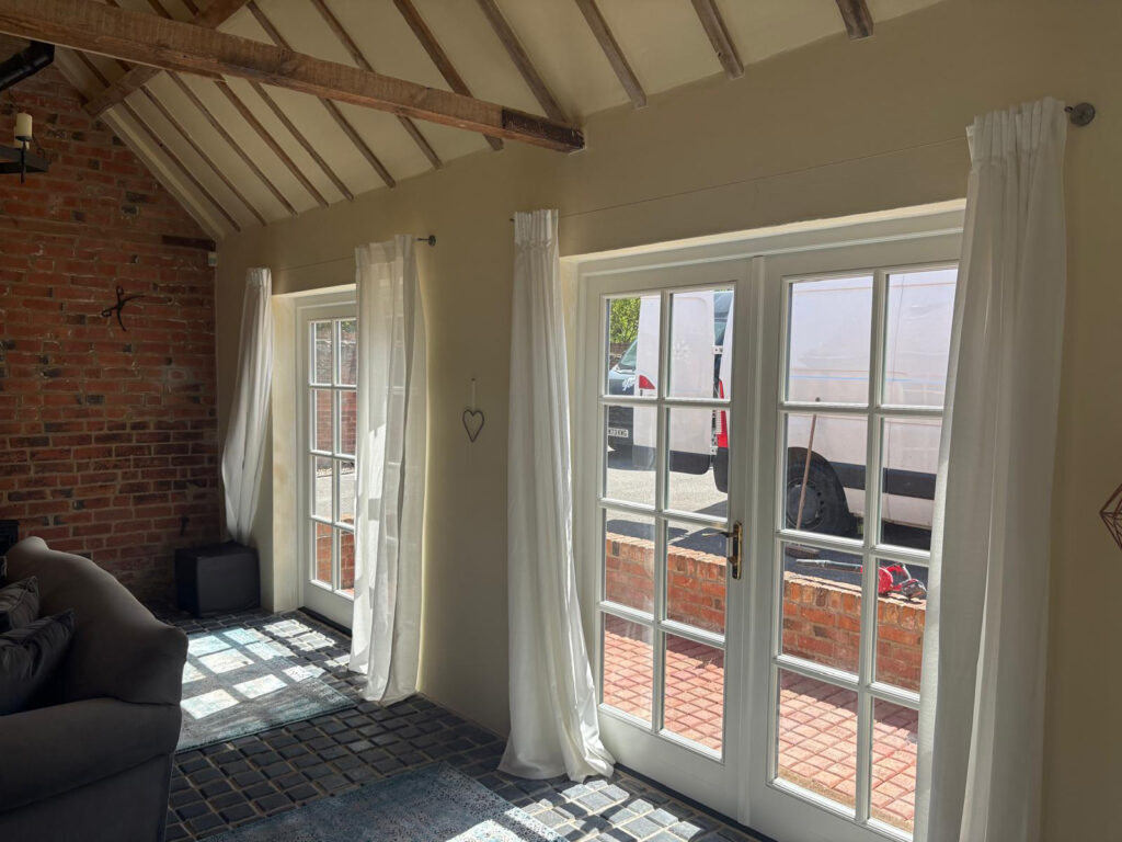 two sets of french doors with georgian glazing bars in a converted barn