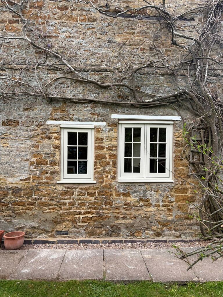 two casement windows next to each other on a stone property