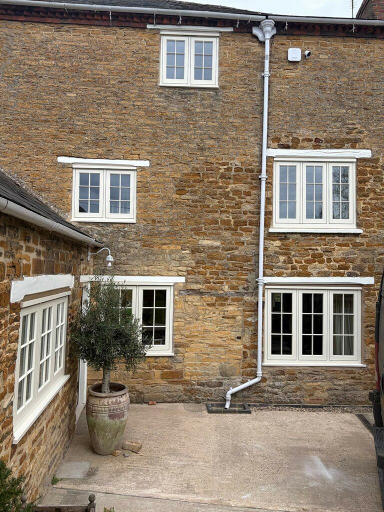 white casement windows with georgian bars on a stone property
