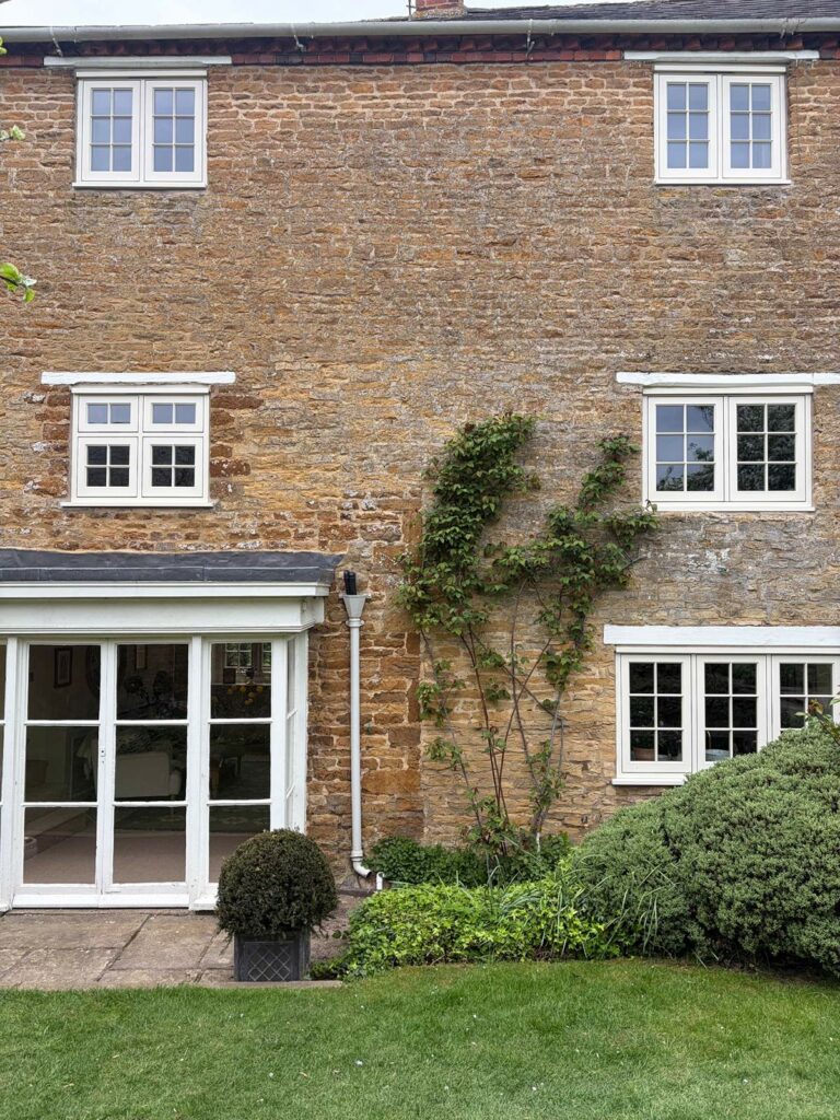 white casement windows with georgian bars on a stone property