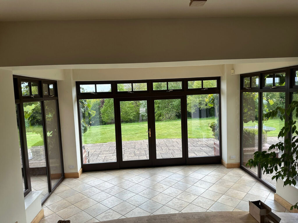 a large empty room with brown french doors