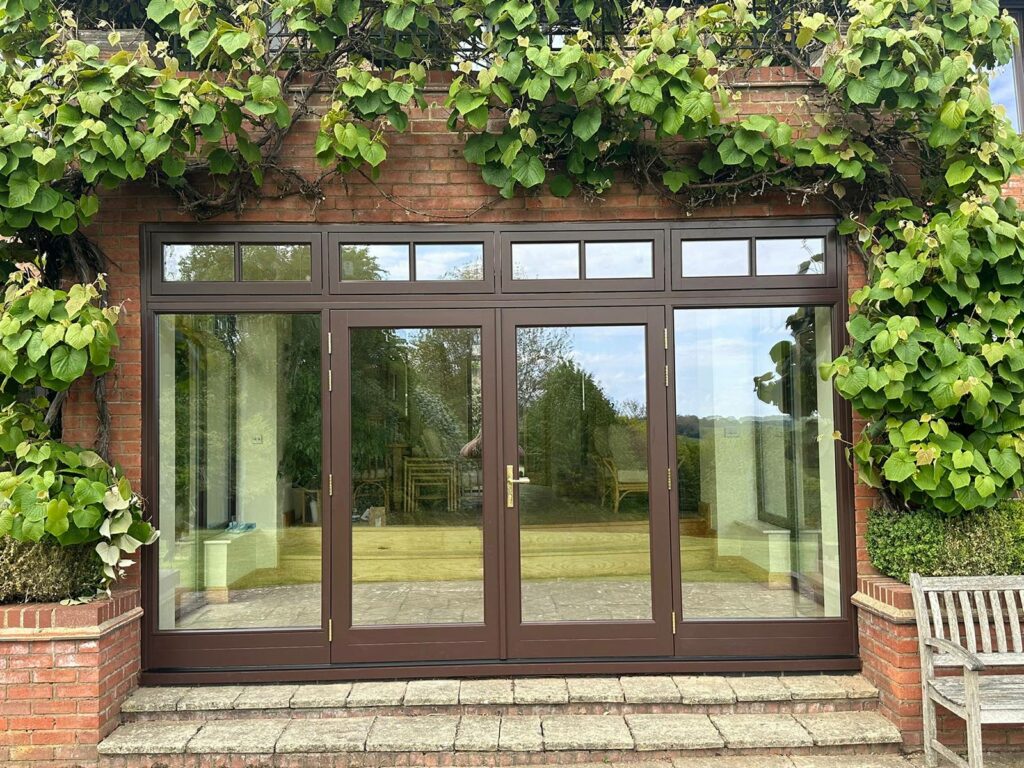 Dark brown french doors with fanlights