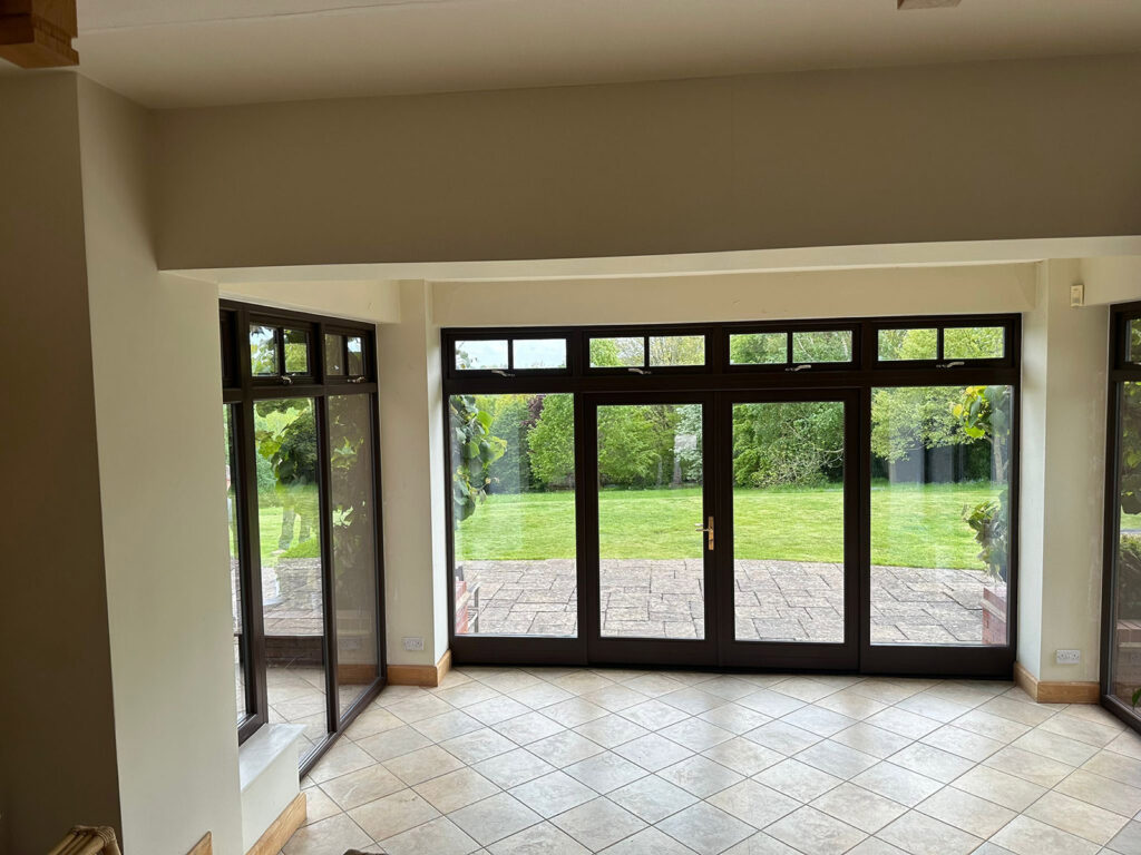 a large empty room with brown french doors