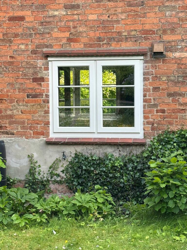 a set of stormproof windows with horizontal glazing bars on a red brick property