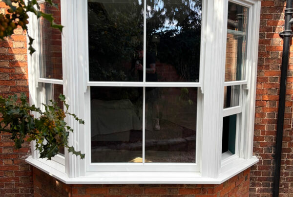 a white victorian sash bay window on a red brick home