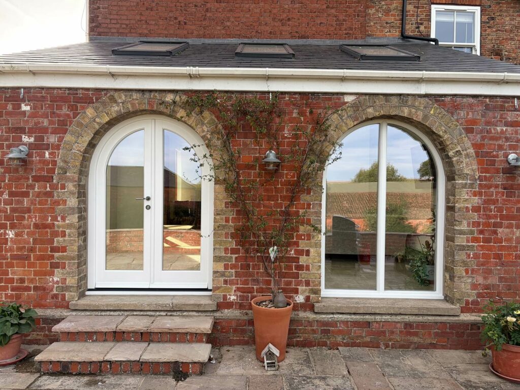 arched french doors on the side elevation of a red brick home