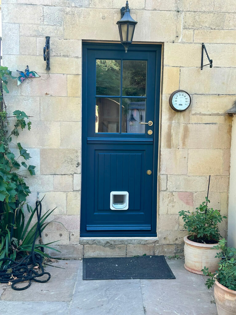 a blue stable door with a white cat flap