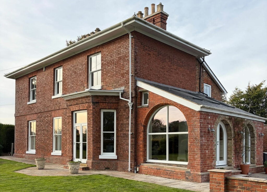 an impressive red brick home with white windows and doors