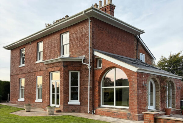 an impressive red brick home with white windows and doors